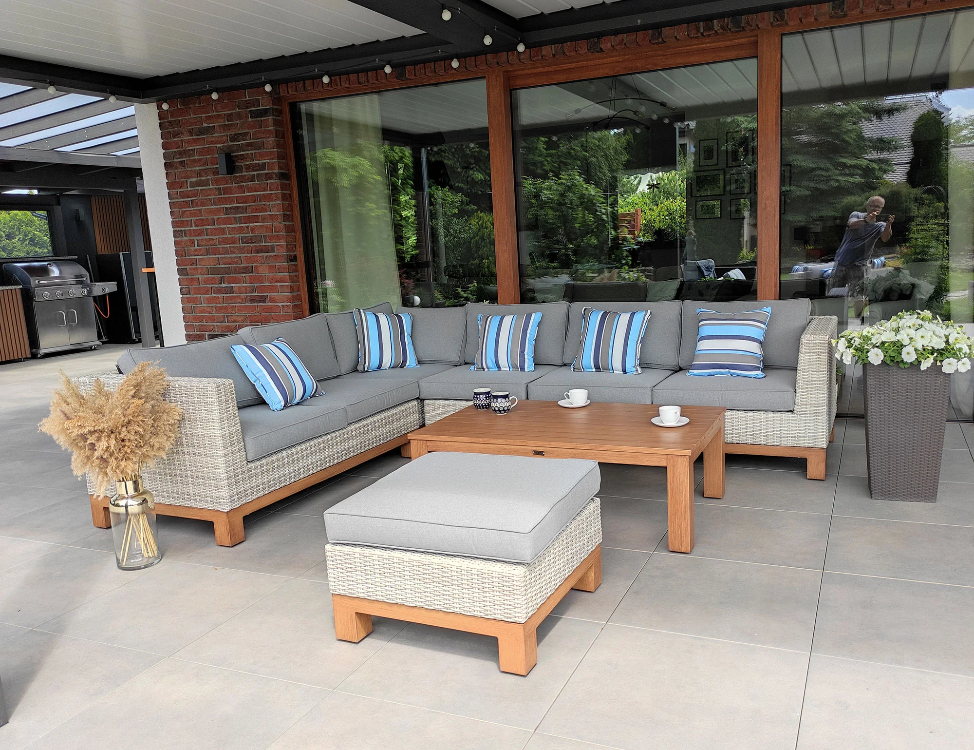 Narożnik ANCONA BIG — widok od przodu pod wiatą, poduszki w niebiesko-szare pasy