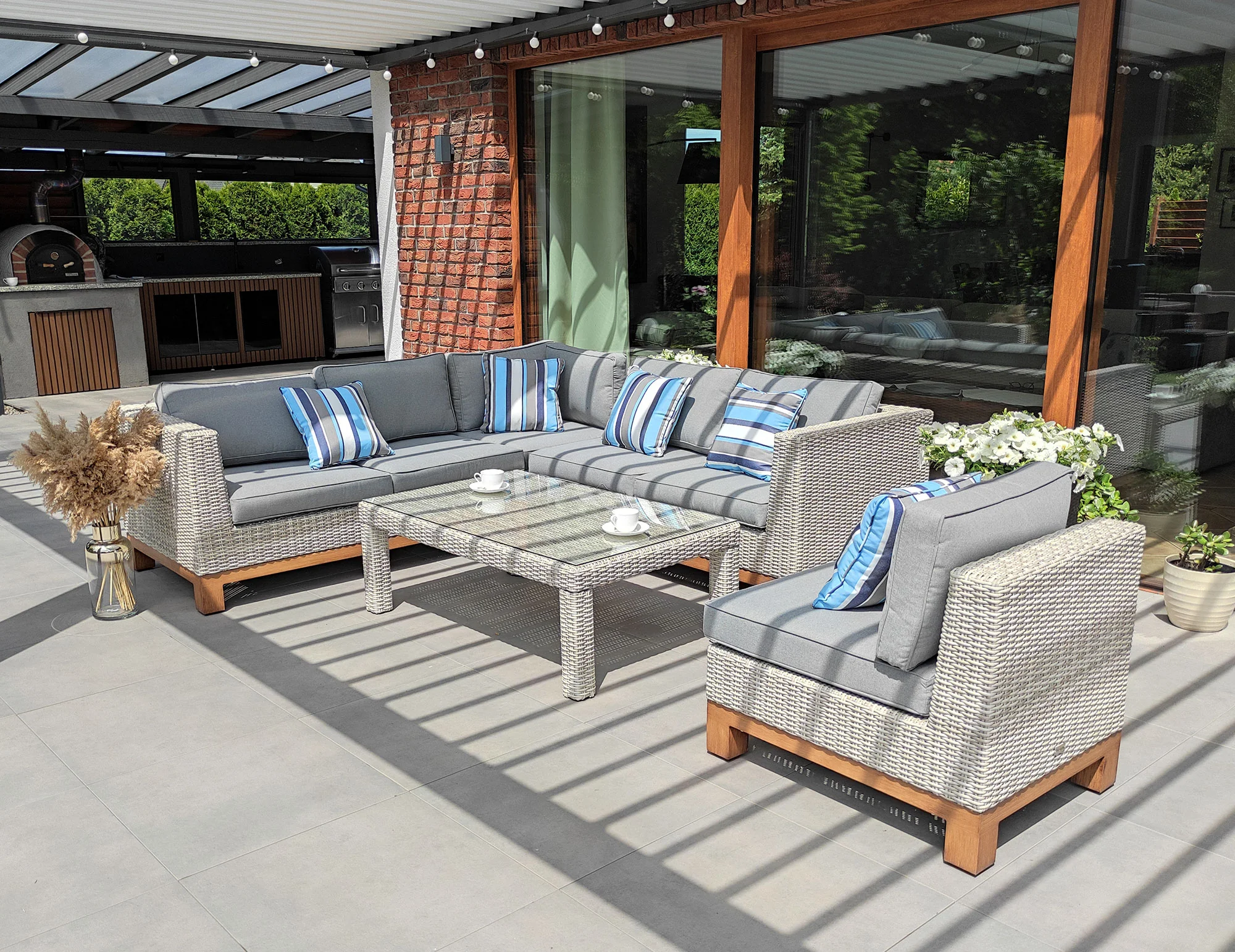 Narożnik ANCONA BIG z prostokątnym stolikiem szklanym — widok z tarasu z fotelem bocznym