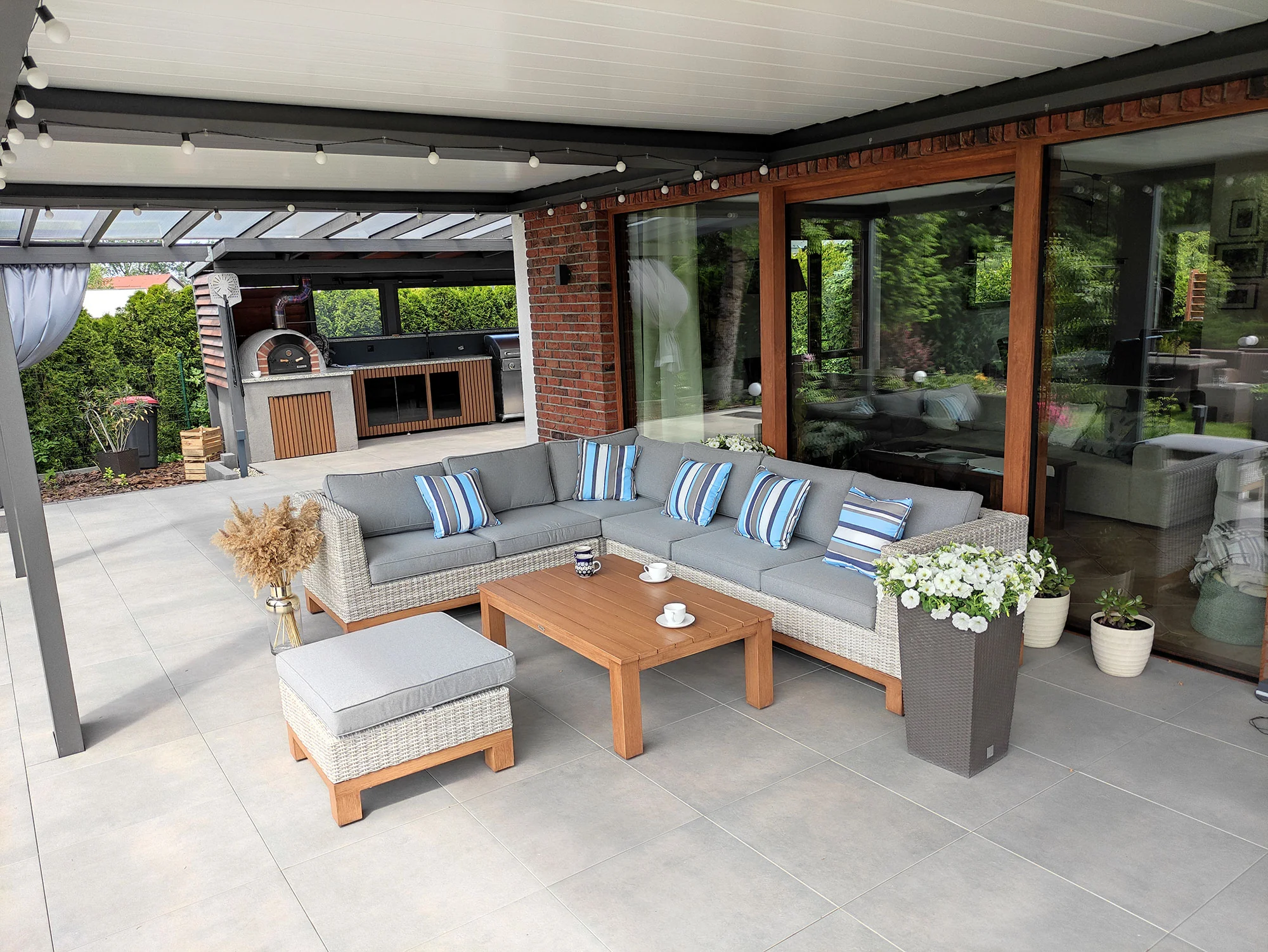 Narożnik ANCONA BIG — zestaw ogrodowy pod pergolą wieczorem, girlandy świetlne