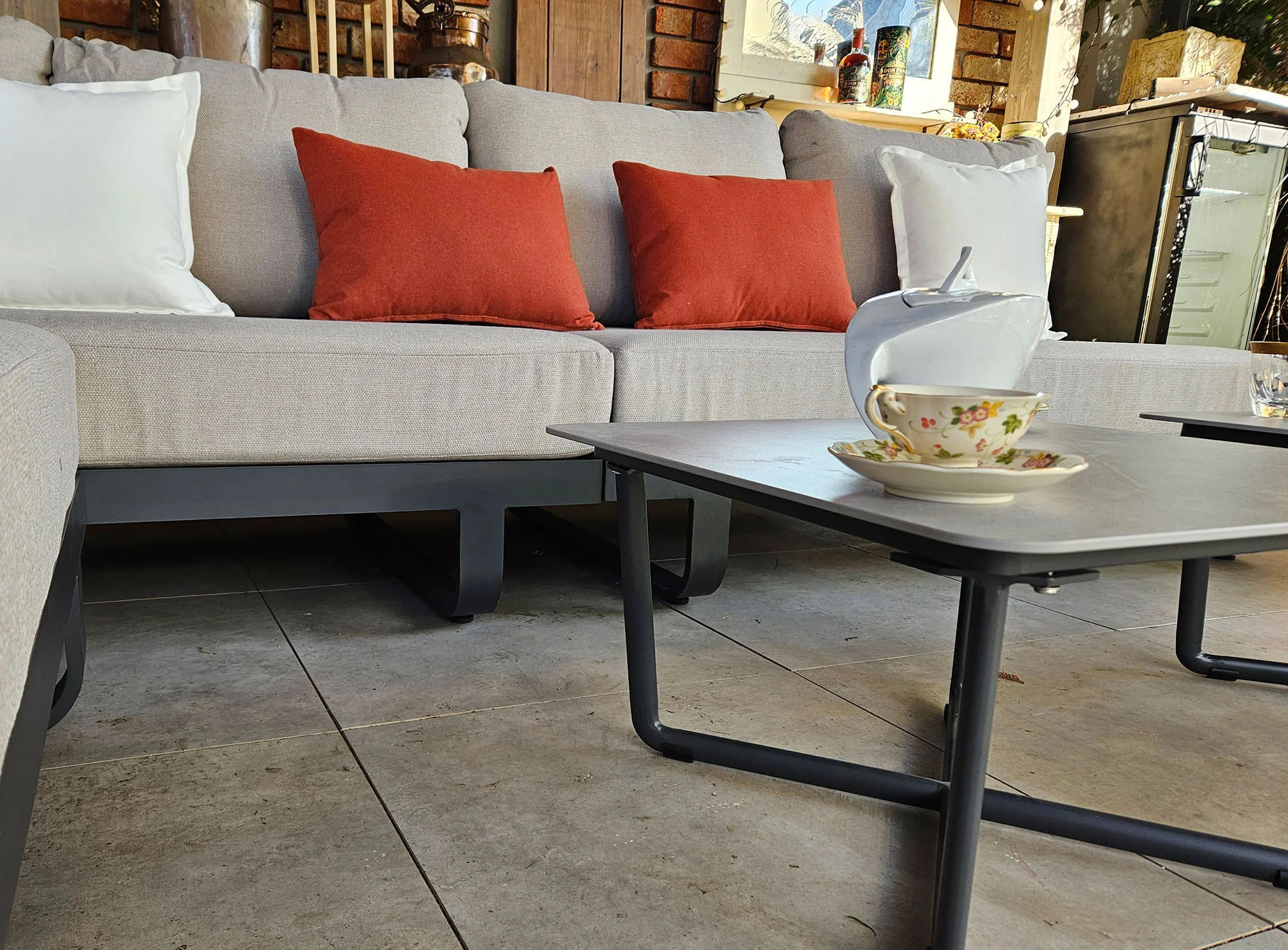 MILETO BIG — zbliżenie na stolik z kamienia spiekanego i poduszki Olefin